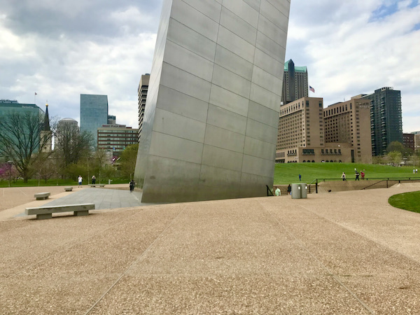 Viewing a small portion of the ground level of the Gateway Arch Saint Louis MO with buildings behind it.