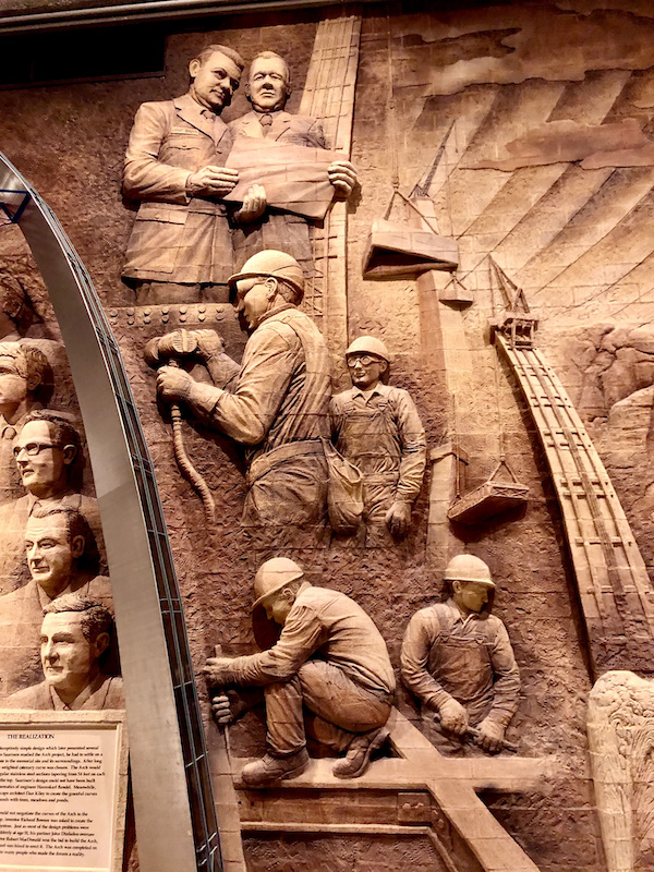 A brick mural depicting men in hard hats building the Gateway Arch Saint Louis MO