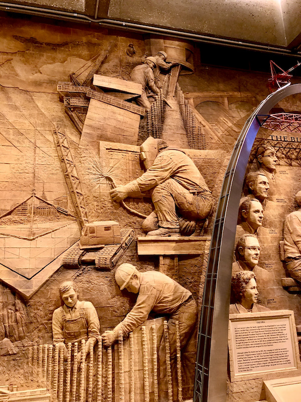 A carved brick facade portion showing men in hard hats working on the Gateway Arch Saint Louis MO