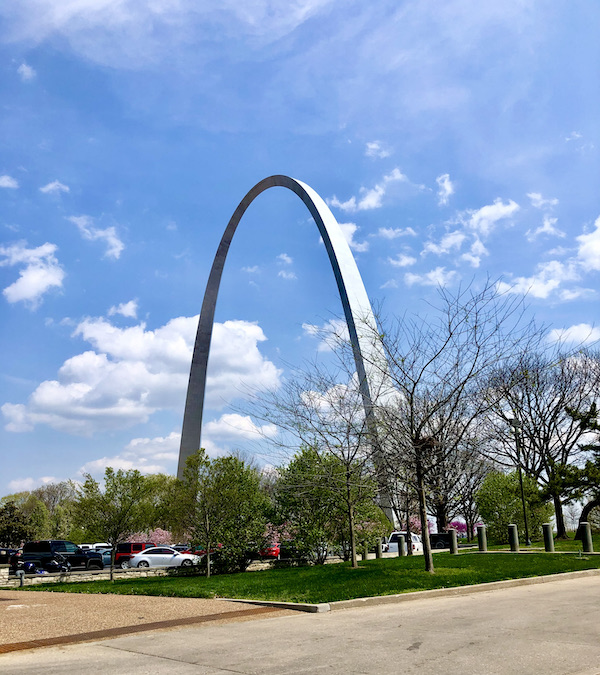 The gateway arch rises above trees and buildings.