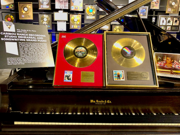 A grand piano with a pair of gold records above the keys at the Musicians Hall of Fame Nashville