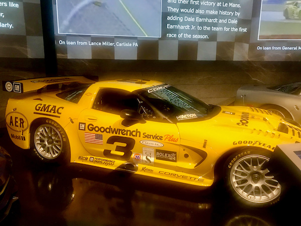A bright yellow race car with black writing at the National Corvette Museum