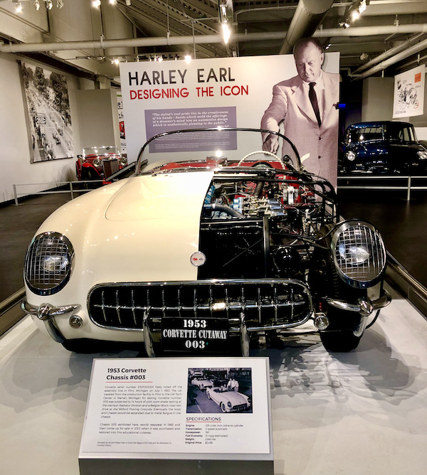 A cream 1953 Corvette with half the engine exposed.