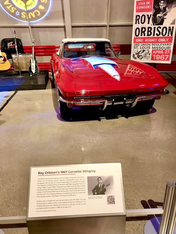 A red Corvette convertible with white detail on hood at the National Corvette Museum