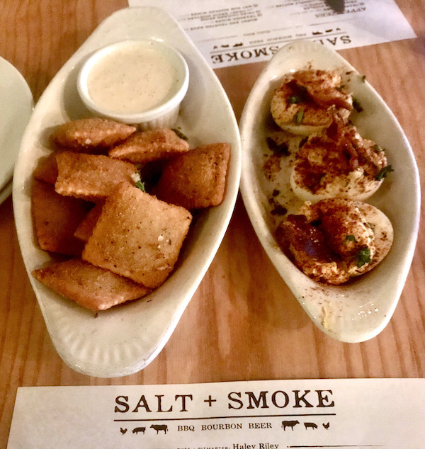 White oval dishes topped with fried ravioli and deviled eggs at Salt + Smoke St. Louis MO