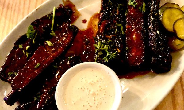 Salt + Smoke St. Louis MO serves their bbq ribs on an oval white platter and creamy white bbq sauce.
