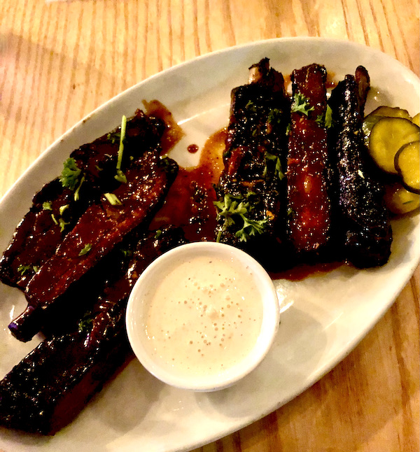 Salt + Smoke St. Louis MO serves their bbq ribs on an oval white platter and creamy white bbq sauce.