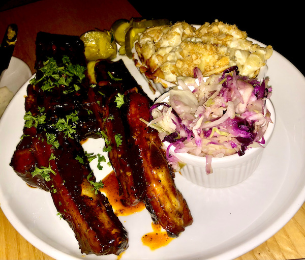 A large white plate topped with bbq ribs, a dish of mac and cheese and a dish of coleslaw at Salt + Smoke St. Louis MO