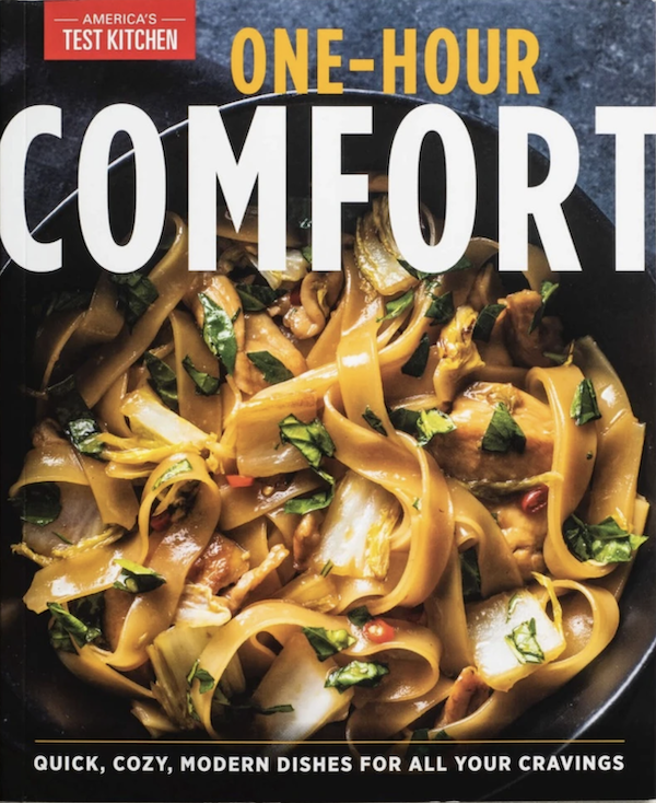 A cookbook cover with a bowl of ribbon pasta and sauce and the title One Hour Comfort from A Trio from America's Test Kitchen