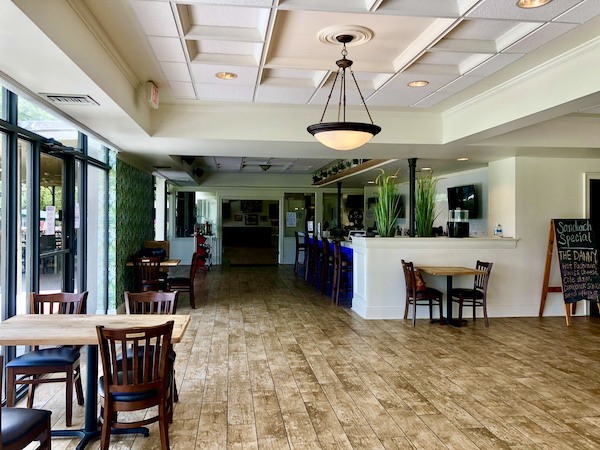 A restaurant dining room with light wood floors at Café Hope Gretna Louisiana