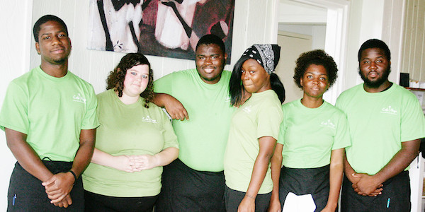Six young men and women in light green T-shirts with black pants at Café Hope Gretna Louisiana
