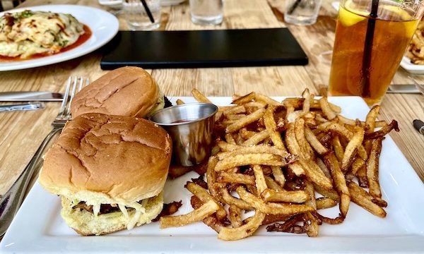 An oblong white plate topped with two crab cake sliders and fries at Café Hope Gretna Louisiana