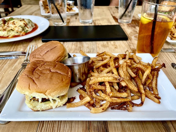 An oblong white plate topped with two crab cake sliders and fries at Café Hope Gretna Louisiana
