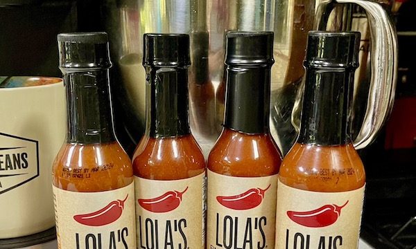 Four bottles of hot sauces on a kitchen counter from Fabulous Gifts for Campers