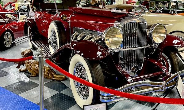 A burgundy antique car with white soft top at Tallahassee Automobile Museum