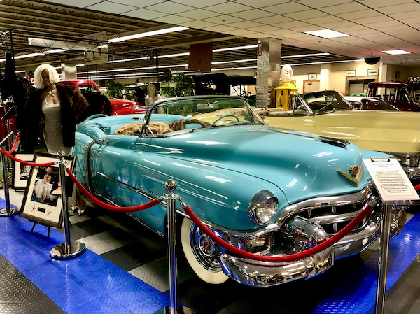 A turquoise antique Cadillac convertible.