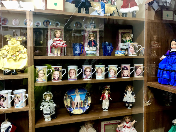 A case with dolls and coffee mugs os Shirley Temple.