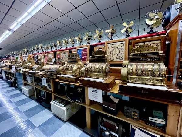A row of brass slot machines and fans collected at Tallahassee Automobile Museum