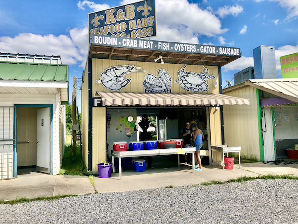 A yellow storefront with red and white striped awning at Westwego Shrimp Lot Louisiana
