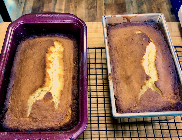 Two A Taste of Sunshine Lemon Cakes in pans cooling on a wire rack.