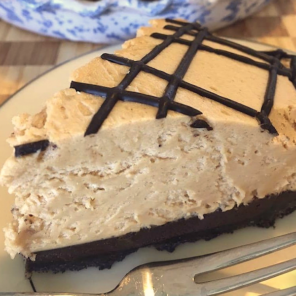 A slice of fluffy peanut butter pie with chocolate crust and drizzle of chocolate on top from Just a Few Miles South