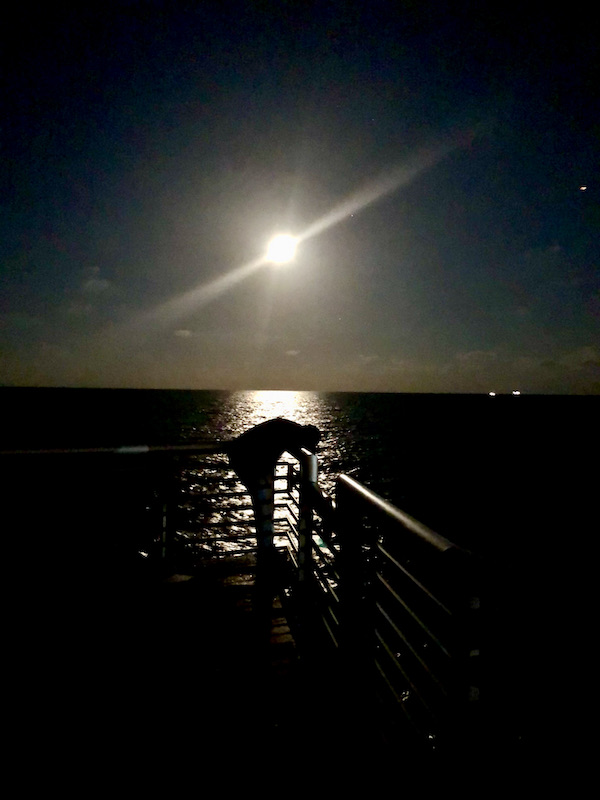 Full moon illuminating the ocean and fisherman at Pompano Pier