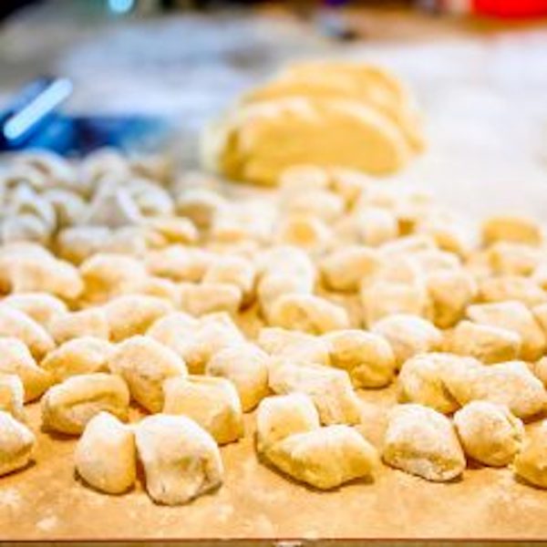 A wood cutting board topped with gnocchi from Sobremesa - A Memoir of Food and Love