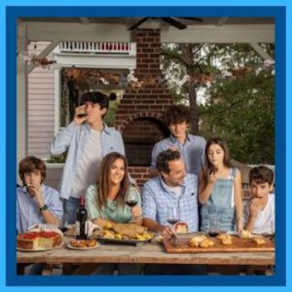 A family of 7 at a table with food from Sobremesa - A Memoir of Food and Love