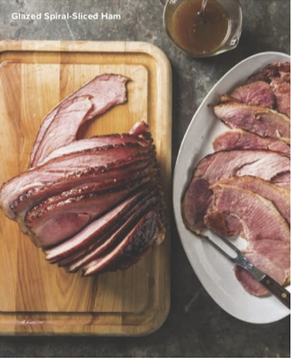 A cutting board and a white platter topped with sliced ham from The Complete Autumn and Winter Cookbook