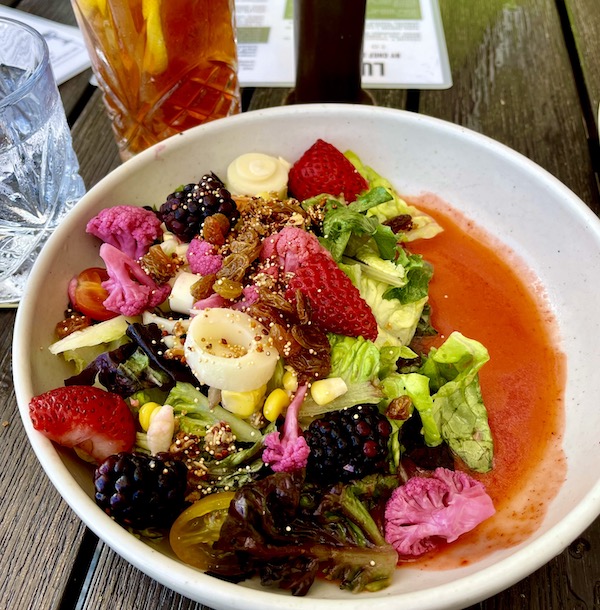 A large shallow bowl with artistically arranged fruit and vegetables at Viva La Playa at Lake Worth Beach