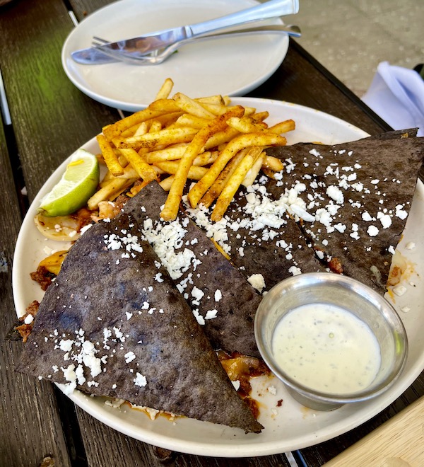 A platter of black bean tortilla wedges, a dipping sauce and fries at Viva La Playa at Lake Worth Beach