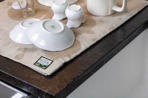 A beige wool drying mat with white dishes draining from 15 Best Gifts for Foodies and RVers