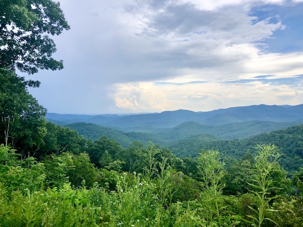 Mountains in the distance, cloudy sky and a tree framing the left top corner at Art Mecca Asheville North Carolina
