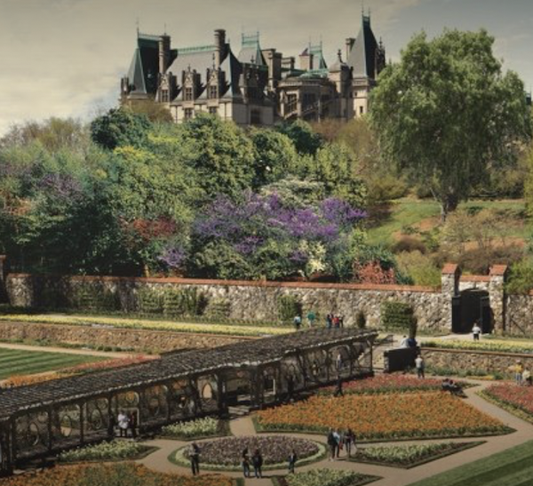 A mansion high on a hill with trees and landscaping in the foreground at Art Mecca Asheville North Carolina