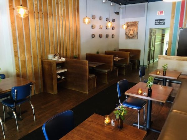 The interior of a restaurant dining room with wood tabletops and decor at Copper Crown Restaurant Asheville NC