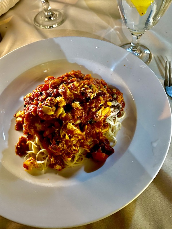A large white plate topped with noodles, seared tuna, crab, tomatoes capers at La Padella Ristorante Ventnor NJ