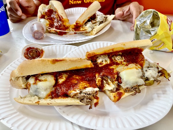 Two plates topped with cheesesteaks with tomato sauce on Our Pilgrimage to the Jersey Shore