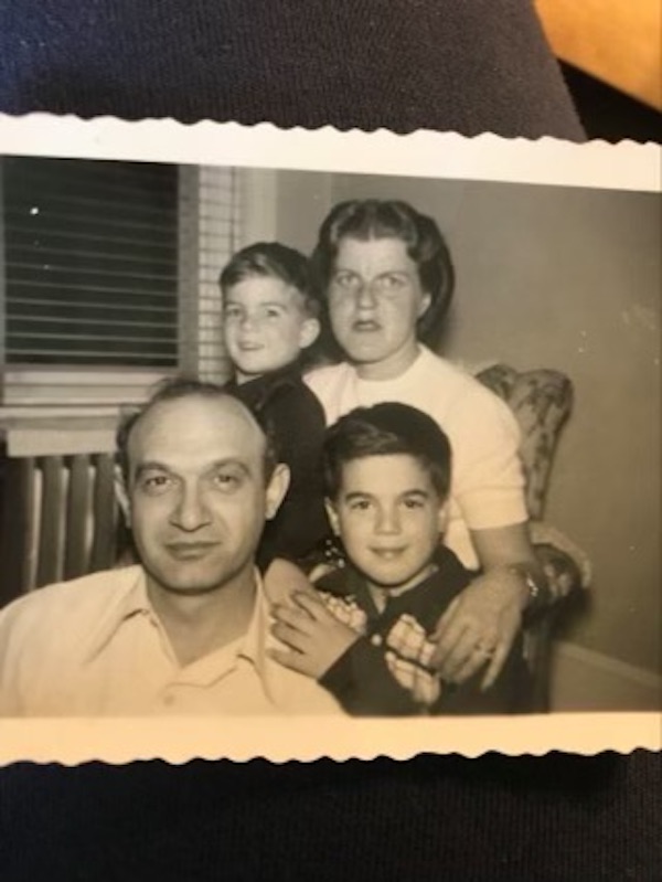 An old black and white photo of a man, woman and two boys.