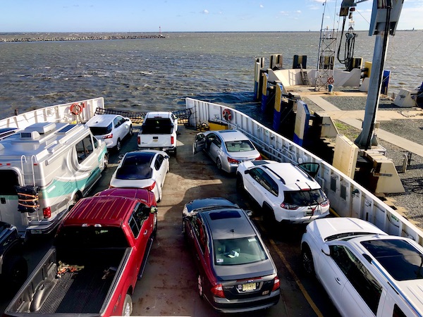A ferry on the water with lots of cars loaded on it.