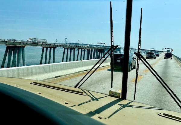 The view from inside an RV on a bridge crossing a body of water.
