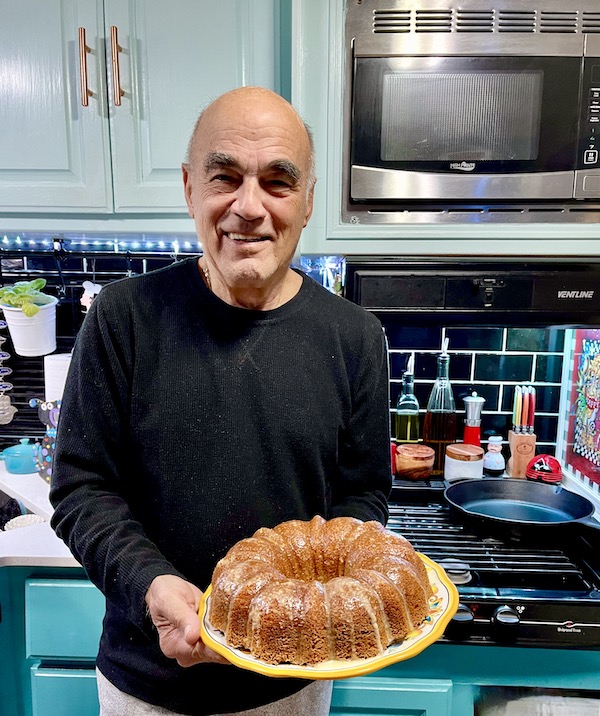 A man in a black sweater showing off his Sour Cream Coffee Cake