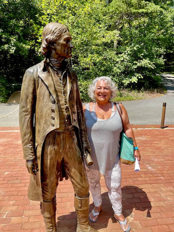 A bronze sculpture of Thomas Jefferson with a woman standing next to him at Thomas Jefferson's Monticello