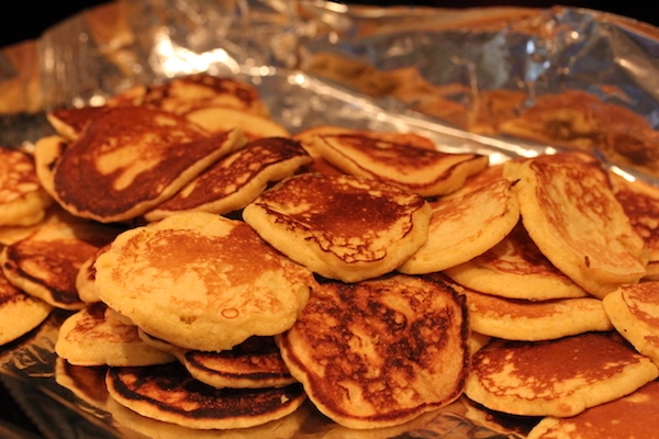 A pile of tiny yellow corn pancakes.