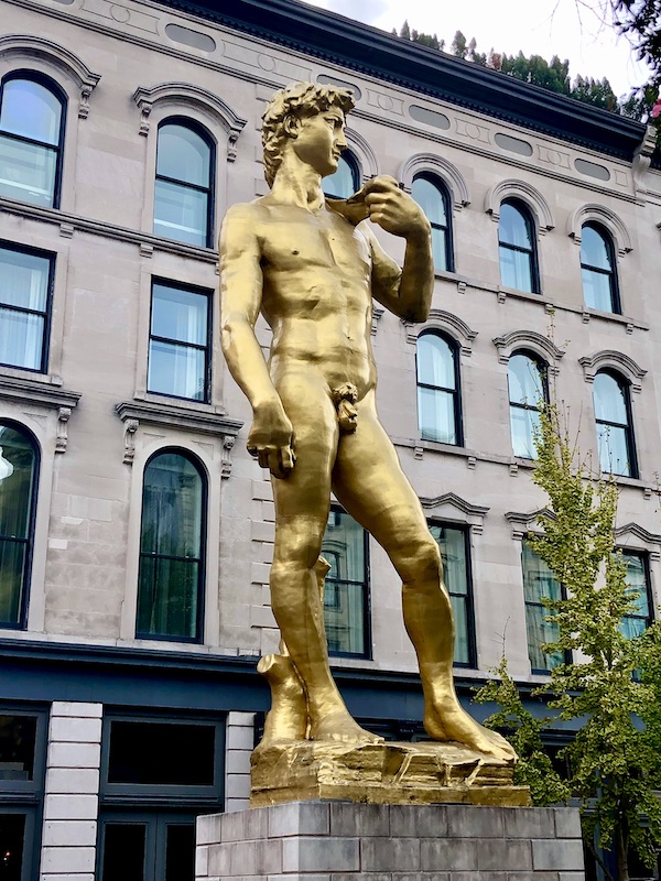 A gold statue of David in front of a hotel in Downtown Louisville Kentucky