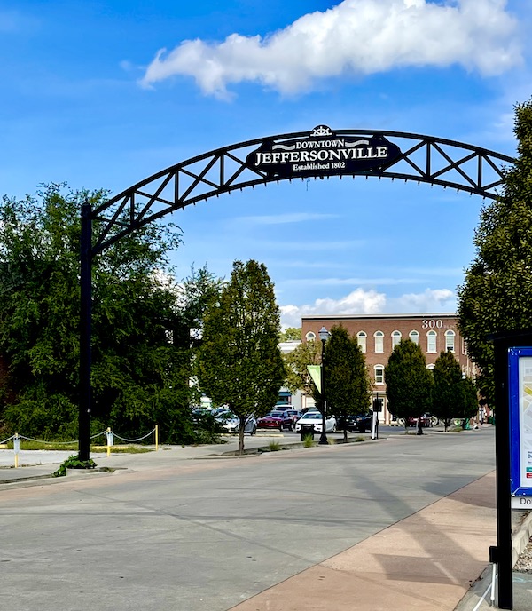 An arch over a street lined with trees welcoming you to downtown Jeffersonville Indiana