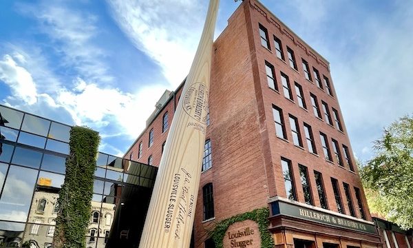 A 5-story red brick building with a baseball bat leaning against it in Downtown Louisville Kentucky