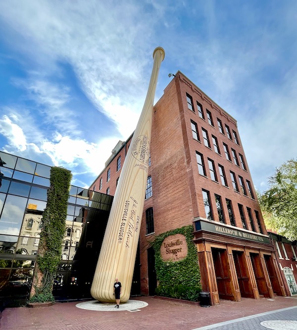 A 5-story red brick building with a baseball bat leaning against it in Downtown Louisville Kentucky
