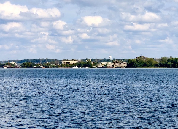 A river with tree and buildings on the far bank.