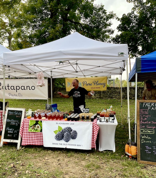 A farm stand of honeys made from different fruits.