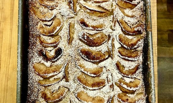 Italian Apple Cake still in the pan dusted with powdered sugar